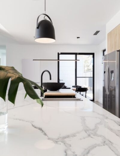 Marble kitchen countertop with modern fixtures and silver refrigerator